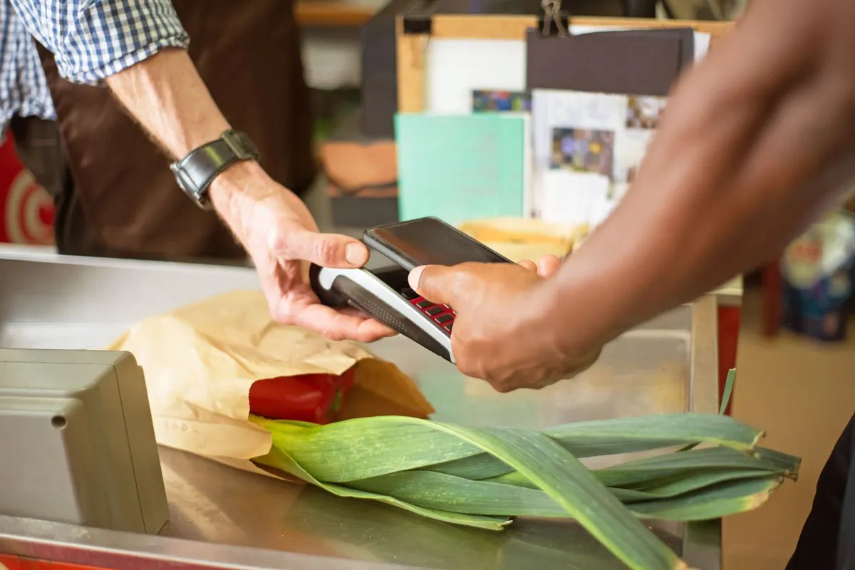 Person paying for produce with their phone 
