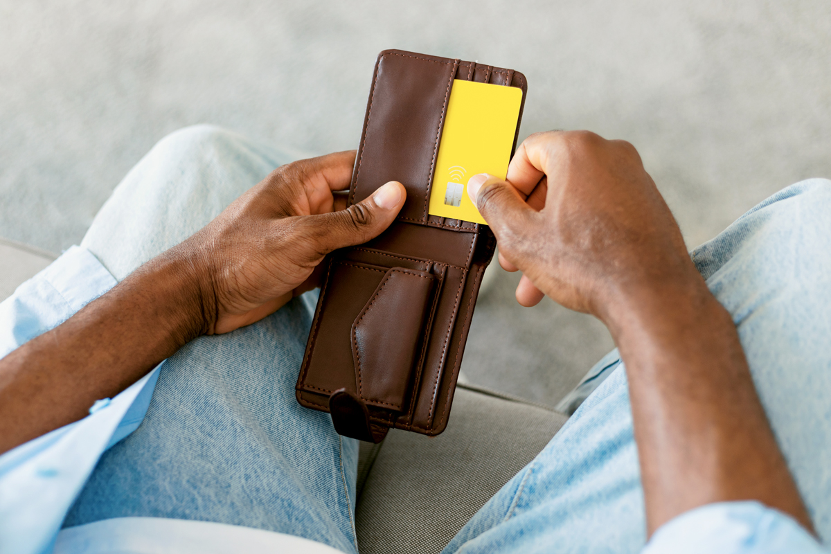 An image of a person pulling a credit card out of wallet 